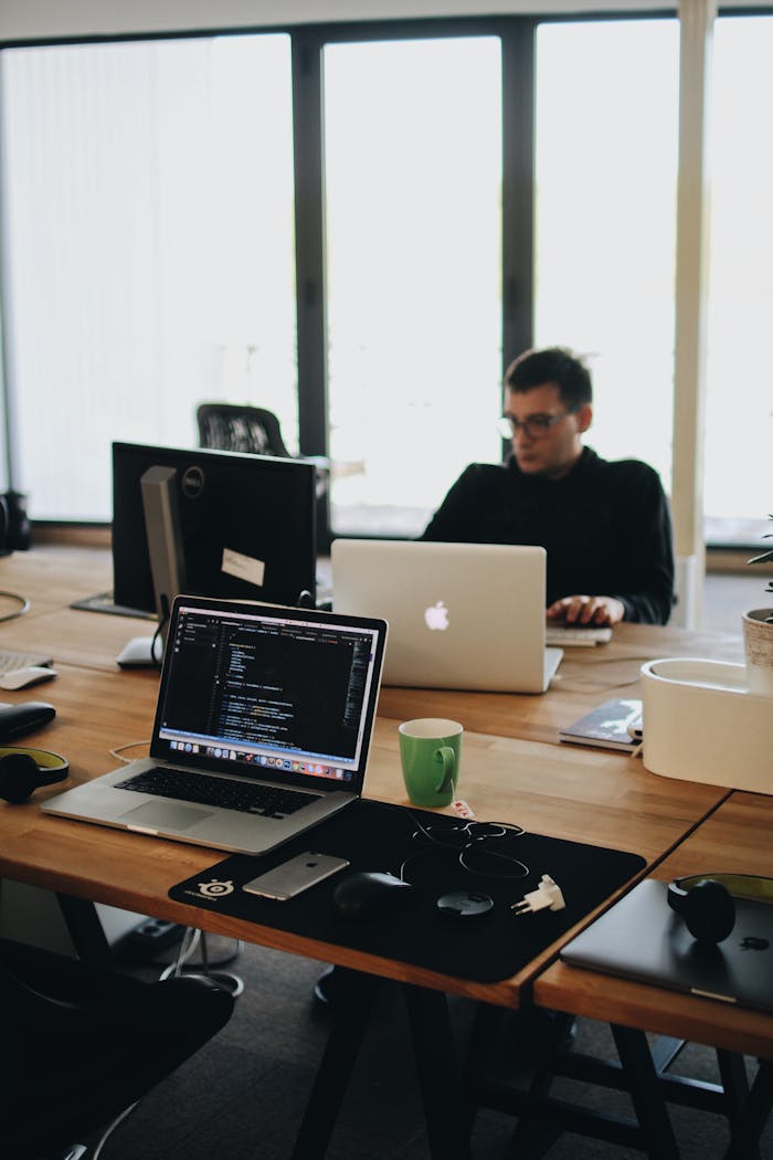 Crafting Captivating Headlines: Your awesome post title goes here A web developer working on code in a modern office setting with multiple devices.