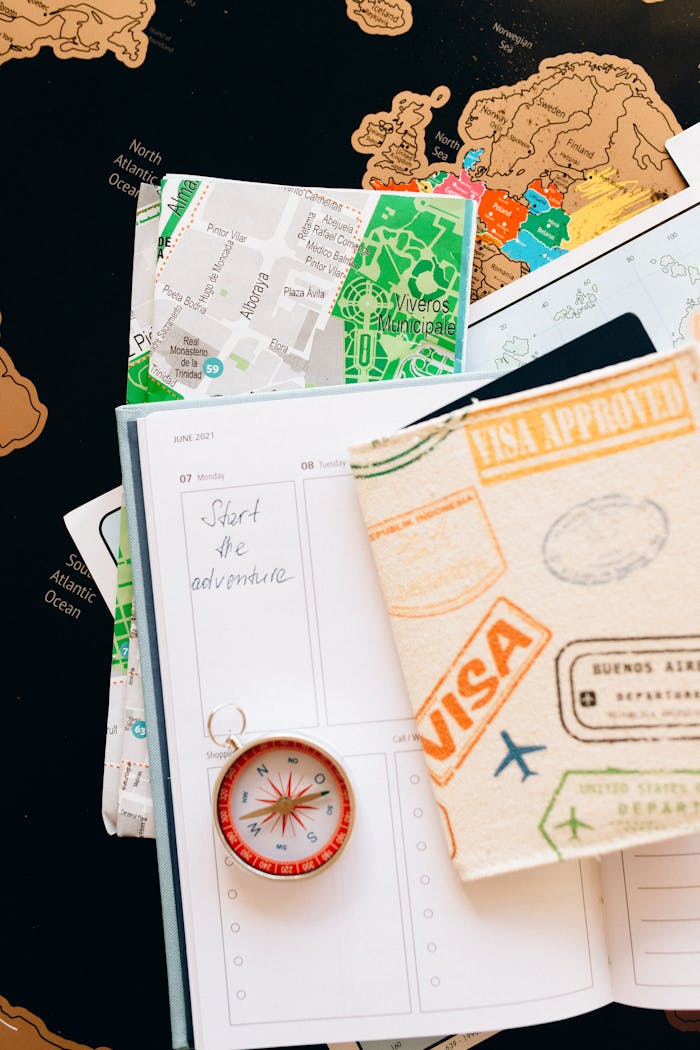 hero-img-02 Flat lay of travel essentials including compass, notebook, and map for a journey.