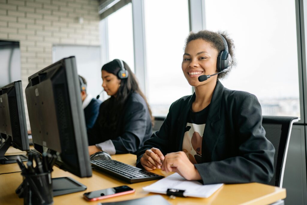 pexels photo 8867213 8867213 Smiling customer service representatives with headsets working in a bright modern office.