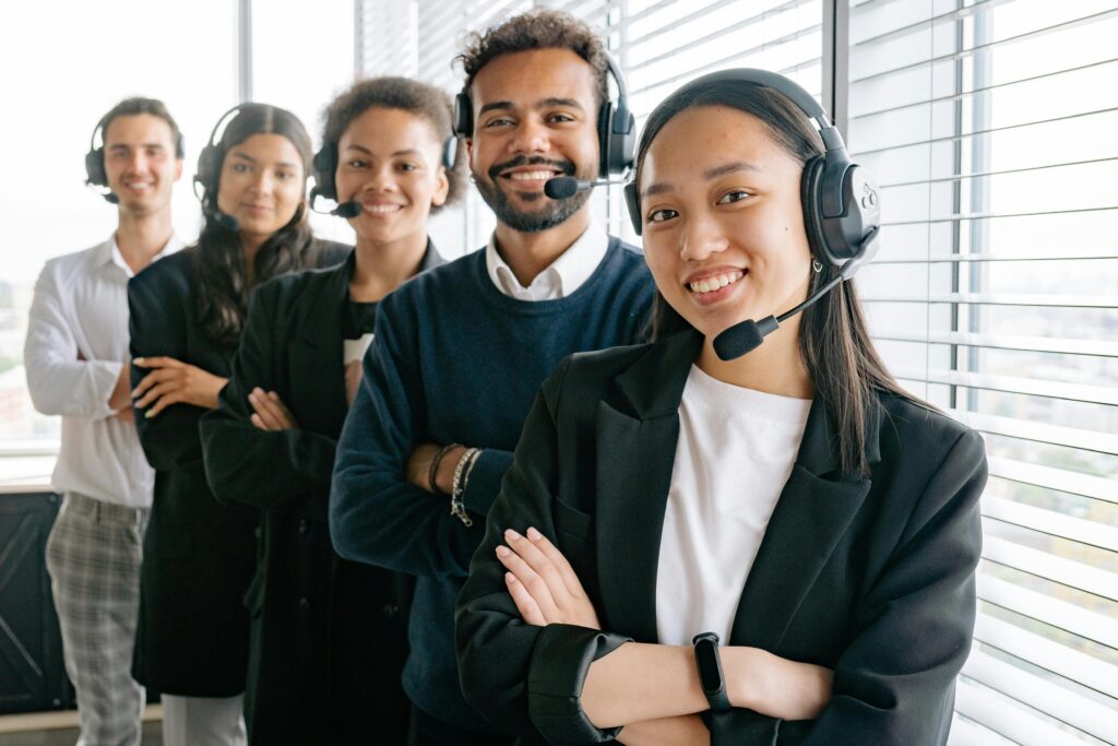 pexels photo 8867482 8867482 A diverse group of smiling call center agents in an office setting.